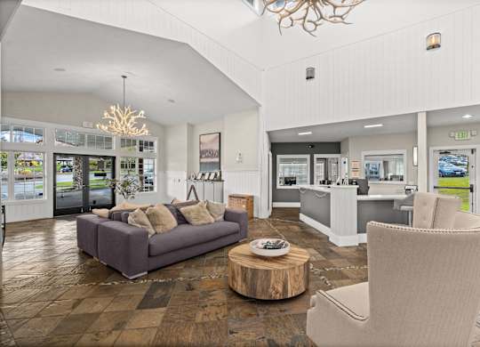 A living room with a grey couch and a wooden coffee table.