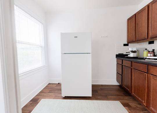 a kitchen with a white refrigerator and wooden cabinets at Edwards on Fifth, Washington, 98121