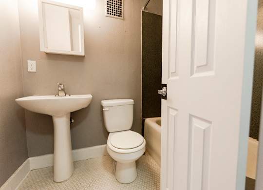 A white toilet and sink in a small bathroom.