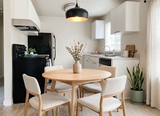 A kitchen with a table and chairs.