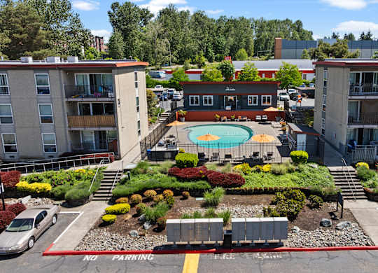 A pool surrounded by buildings and a no parking sign.