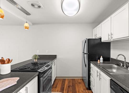 A kitchen with black appliances and white cabinets.
