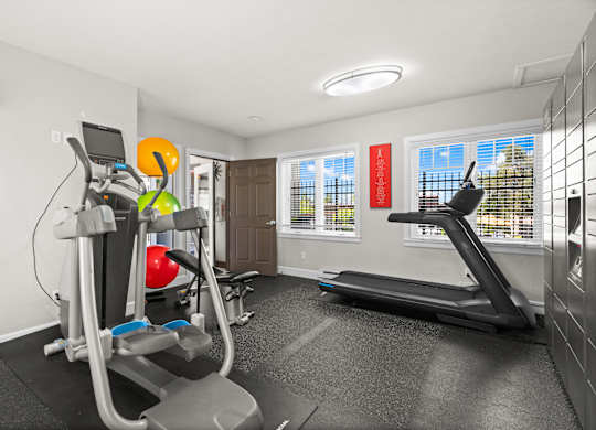 A home gym with a treadmill, elliptical trainer, and other exercise equipment.