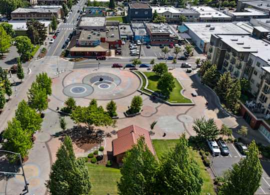 A city square with a fountain in the middle of it.
