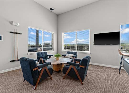 A room with a table and chairs and a television.