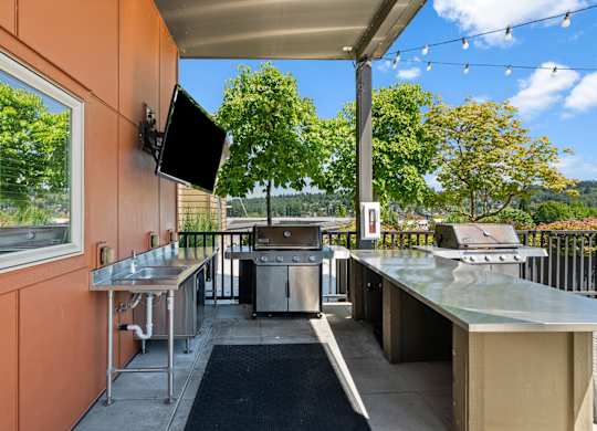 A patio with a television and a grill.