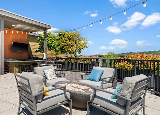 A patio with a table, chairs, and a fire pit.