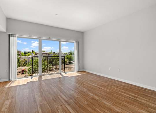A room with a sliding glass door leading to a balcony.