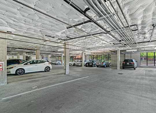 A parking garage with multiple cars parked.