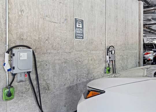 An electric vehicle is charging at a charging station.