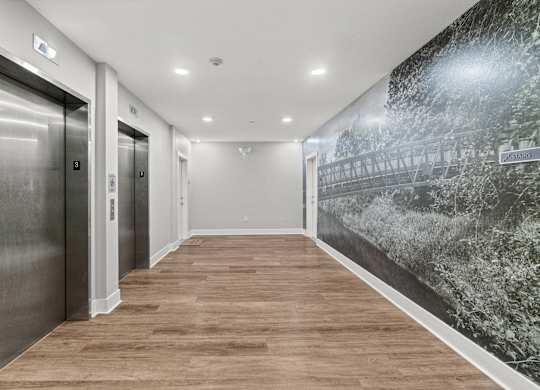 A hallway with wood floors and a wall mural of a bridge.