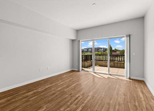 A room with a sliding glass door leading to a balcony.