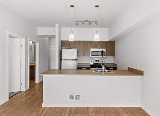 A kitchen with white walls and wooden floors.