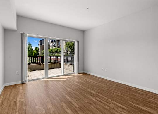 A room with a wooden floor and a sliding glass door.