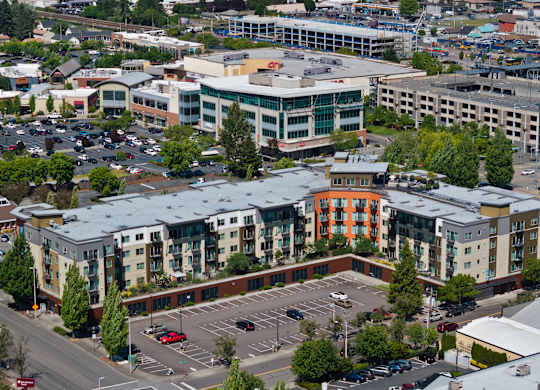 A parking lot is in the foreground of a city scene.