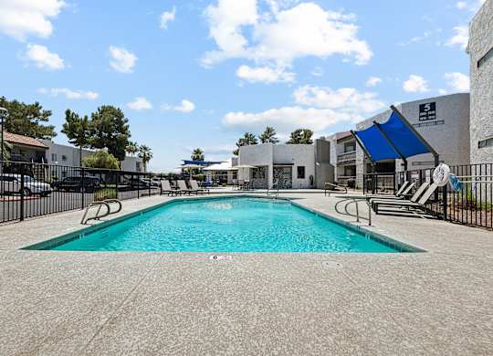 A large swimming pool surrounded by a black fence.