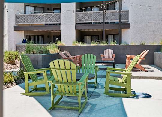 A group of green chairs are arranged on a patio.
