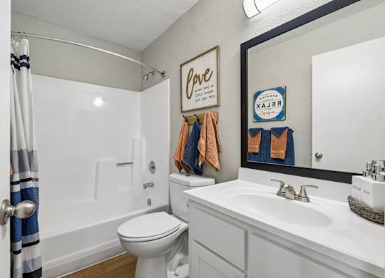A white toilet sits next to a white sink in a bathroom.