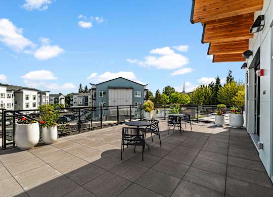 A patio with a table and chairs overlooks a row of houses.