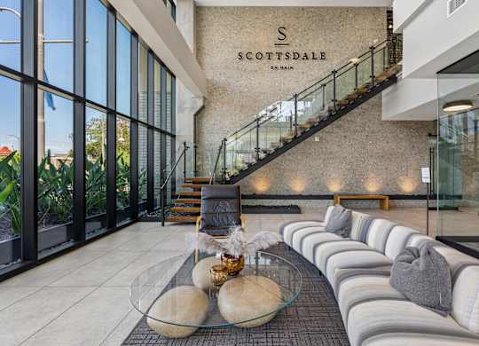 A modern interior space with a glass table and a staircase.