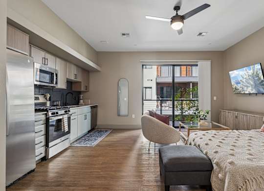 A modern kitchen with a refrigerator, stove, and microwave.