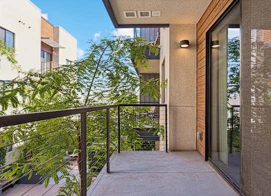 A balcony with a metal railing and a glass door.