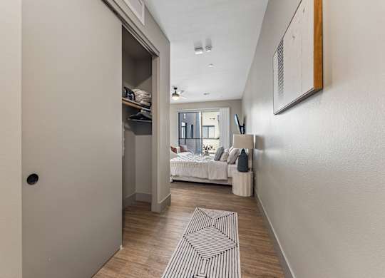 A hallway with a bedroom at the end.