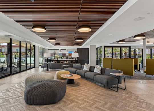 A modern living room with a grey sofa and a wooden ceiling.