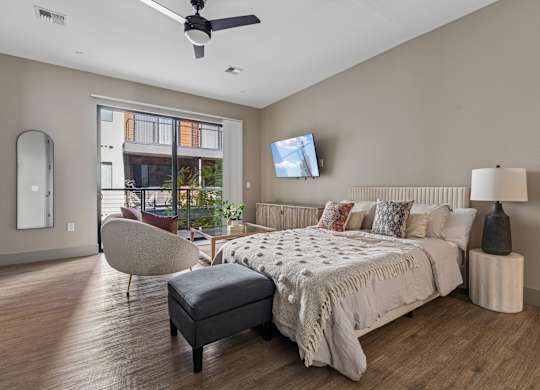 A bedroom with a large bed and a ceiling fan.