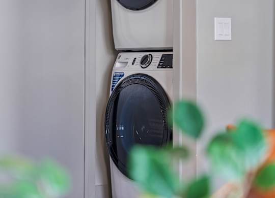 Two washing machines are stacked on top of each other.