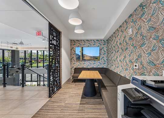 A room with a patterned wallpaper and a long bench.