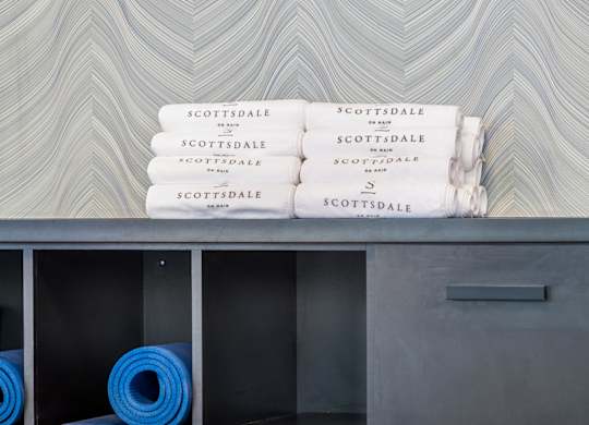 A shelf with yoga mats and towels with the word "Scottsdale" on them.