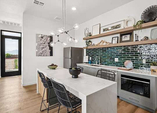 A modern kitchen with a white countertop and a stainless steel oven.