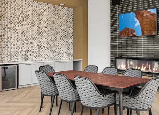 A modern dining room with a wooden table and grey chairs.