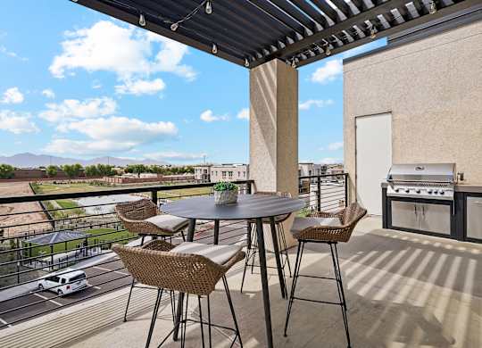 A patio with a table and chairs overlooking a parking lot.