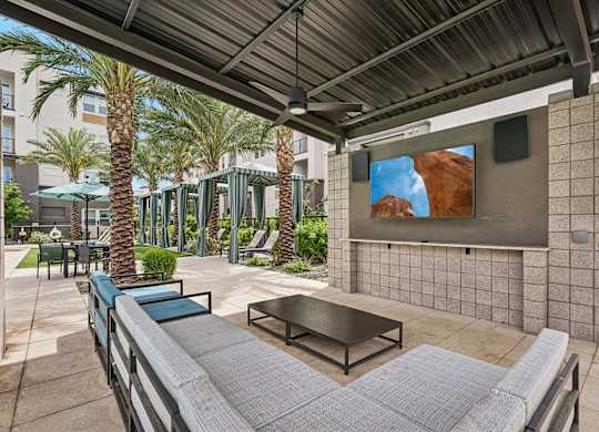 A patio with a table and chairs under a roof.