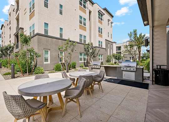 A patio with a table and chairs is in front of a building.
