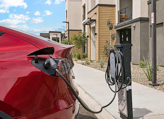 A red car is charging at a station.