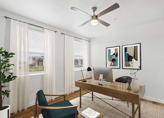 A room with a desk, chair, and a ceiling fan.