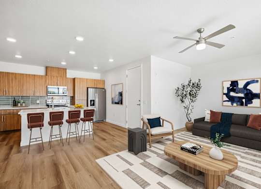 A modern living room with a kitchen area in the background.