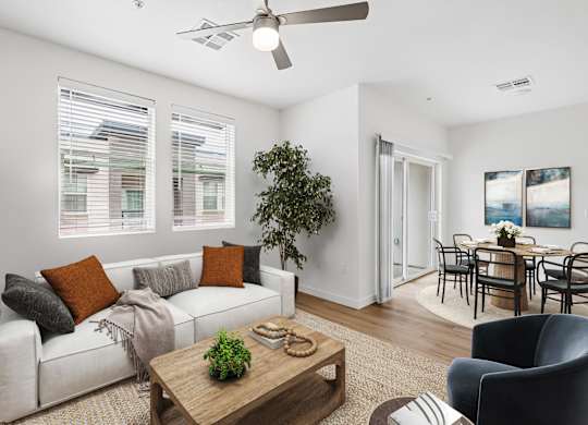 A living room with a white couch, a coffee table, and a ceiling fan.