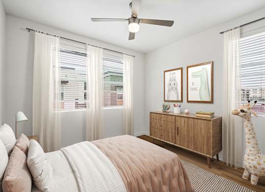 A bedroom with a bed, a giraffe toy, and two framed pictures on the wall.