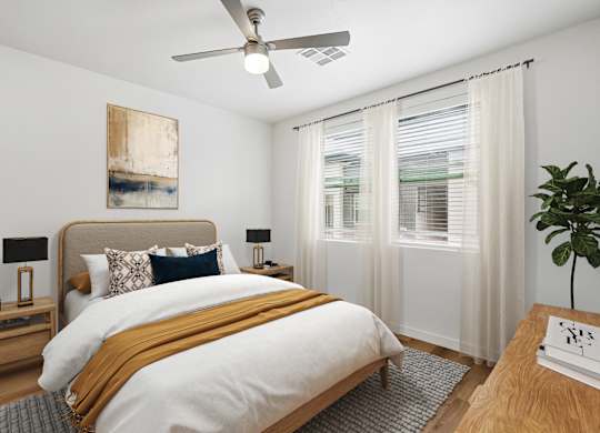 A bedroom with a large bed and a ceiling fan.