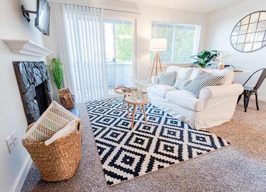 living room with couch and tv with balcony view at ReVive Apartments, Fife, WA