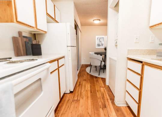 A kitchen with white appliances and wooden cabinets.