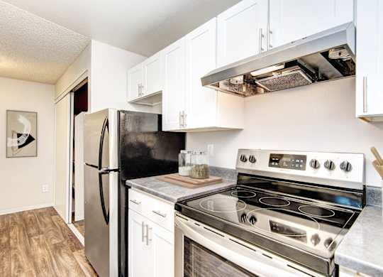 A kitchen with a stove, refrigerator, and oven.