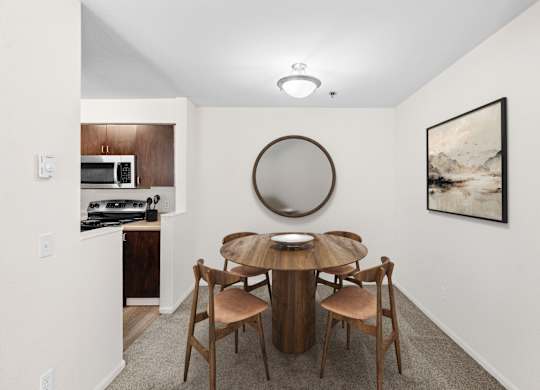 A dining room with a round table and chairs.