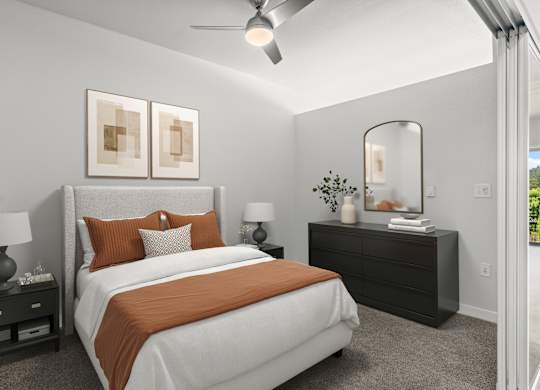A bedroom with a large bed and a ceiling fan.