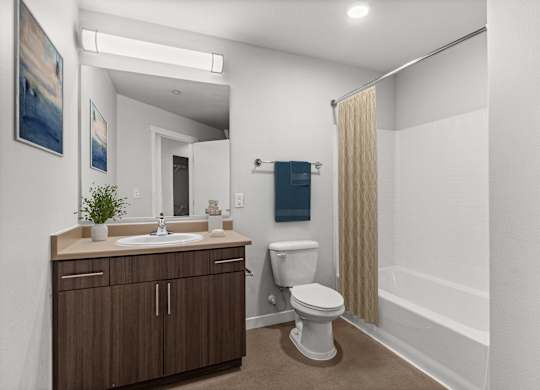A bathroom with a toilet, sink, and mirror.