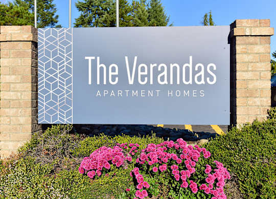 A sign for The Verandas Apartment Homes is displayed in front of a building.